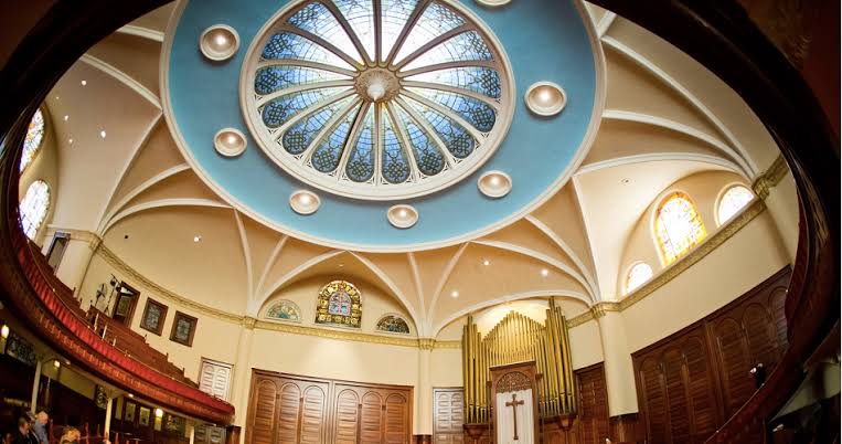 Ornate domed ceiling and stained glass inside the Historic Wesley Center